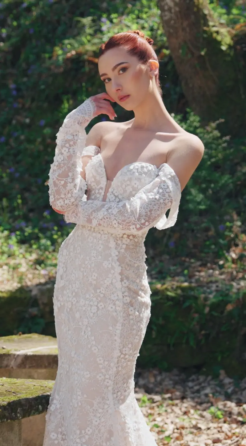 Sposa con abito di pizzo in un giardino