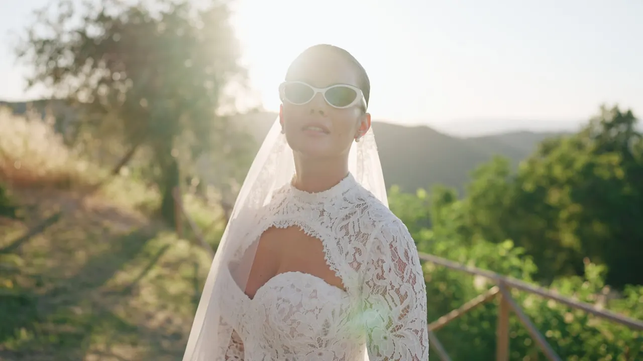 La sposa con il velo e gli occhiali da sole al tramonto sulle colline umbre